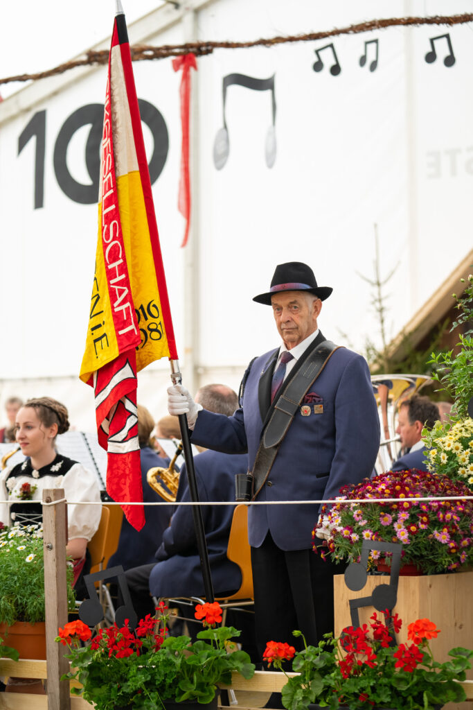 Hans Geissbühler mit Fahne am Emment. Musiktag 2023, Röthenbach