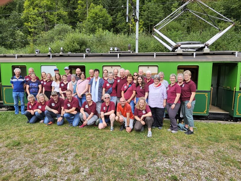 Gruppenbild im Hintergrund die Schmalspurbahn im Jura